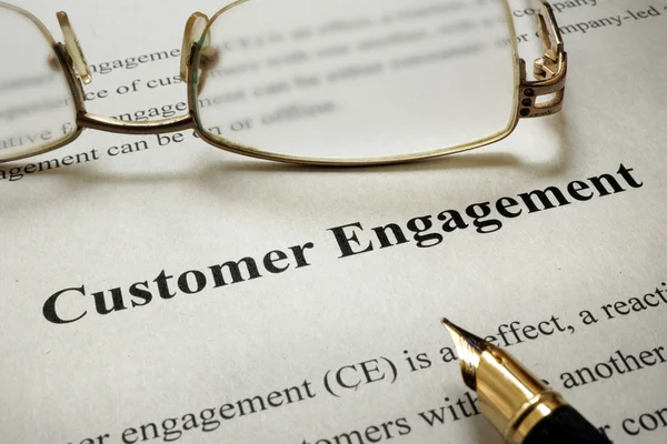 Page of paper with words Customer Engagement and glasses.