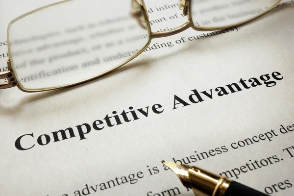 Page of paper with words Competitive Advantage and glasses.