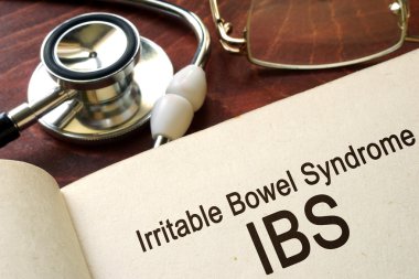 Paper with words Irritable bowel syndrome (IBS) and glasses.  clipart