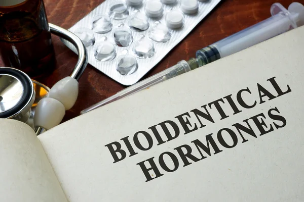 Libro con palabras hormonas bioidénticas en una mesa . — Foto de Stock