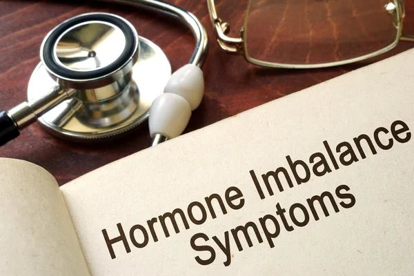 Book with words hormone imbalance symptoms on a table. — Stock Photo, Image