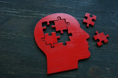 Yapboz parçaları çıkarılmış insan kafası şekli. Alzheimer hastalığı ve hafıza sorunları.
