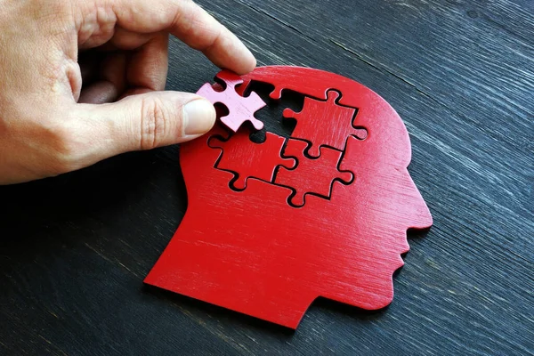 Mentális betegségek és memória problémák kezelése. A kéz tesz egy darab a puzzle a forma a fej. — Stock Fotó