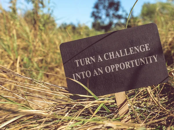 Turn challenge into opportunity the inscription on the sign on the path.