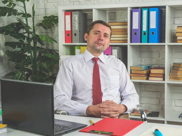 Retrato de un empleado, gerente sentado a la mesa en la oficina. — Foto de Stock