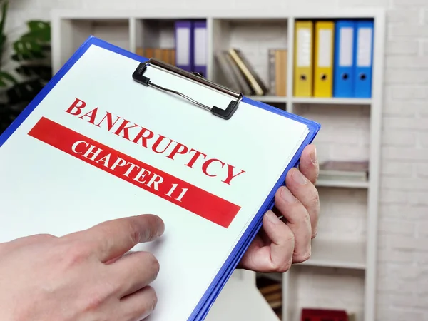 The banker reads the chapter 11 of the bankruptcy law. — Stockfoto