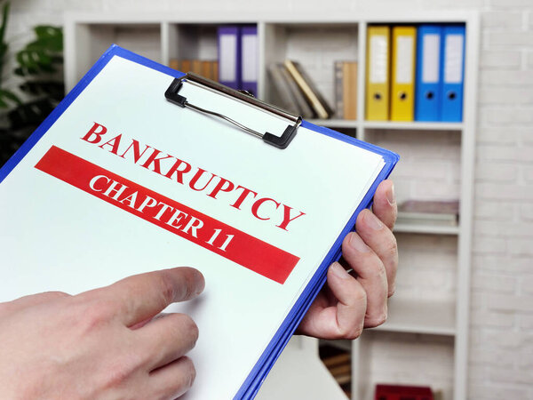 The banker reads the chapter 11 of the bankruptcy law.