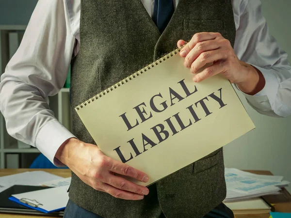 The clerk holds a book about legal liability. — Stock Photo, Image