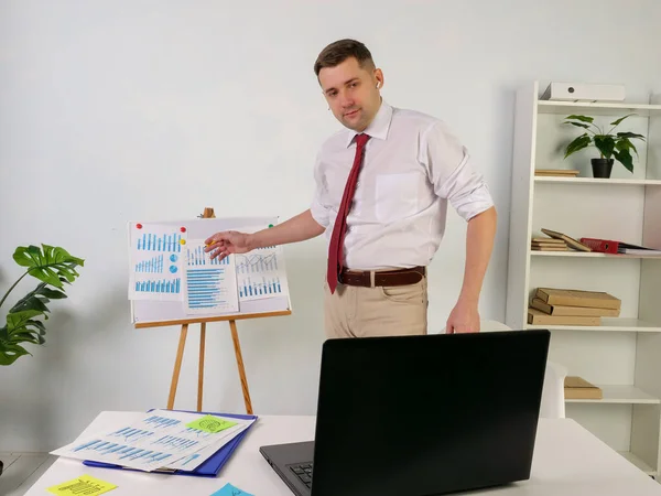 Presentación de negocios en línea en Internet. Un hombre se comunica con sus colegas con una computadora portátil. — Foto de Stock