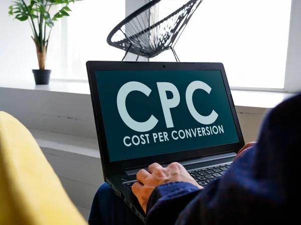 Un hombre lee acerca de Costo por Conversión CPC en Internet. — Foto de Stock