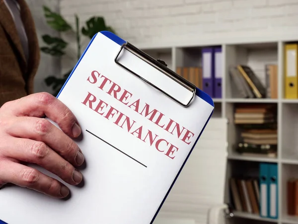 Hand innehar papper för Streamline refinance och Urklipp. — Stockfoto