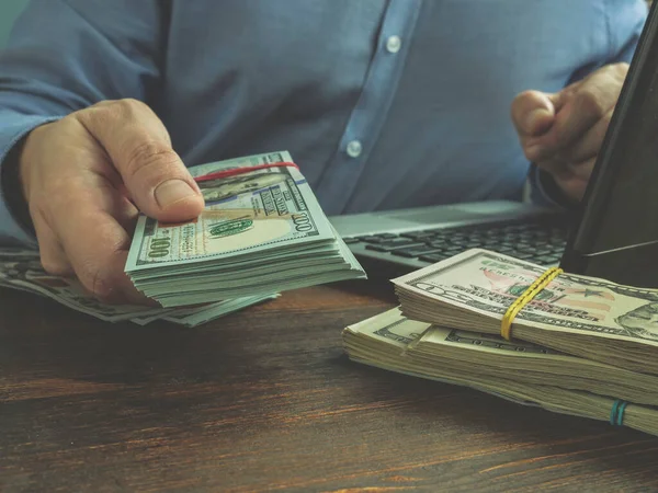 Payday cash lening online concept. Man met laptop biedt geld. — Stockfoto