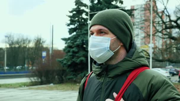 Die Kamera schwenkt bei kaltem Wetter um einen Mann mit medizinischer Schutzmaske. — Stockvideo