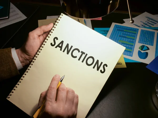 Ruce drží seznam ekonomických sankcí. — Stock fotografie