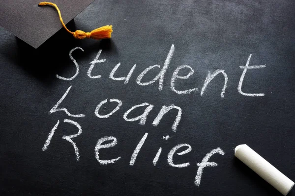 Alivio de préstamo estudiantil escrito en la pizarra y el tope de graduación. — Foto de Stock