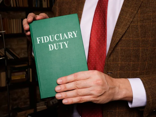 Um homem mostra o livro de direito do dever fiduciário. — Fotografia de Stock