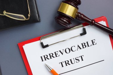 Irrevocable trust document on the clipboard and gavel. clipart