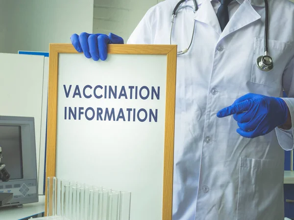 Ellerindeki beyaz tahtada aşı bilgisi işareti var..