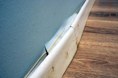 Hasarlı etek tahtası, apartman sular altında kaldıktan sonra duvardan ayrılmış..