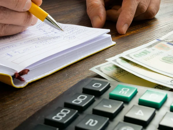 A man makes financial notes and accounting entries for a small business. — Stock Photo, Image