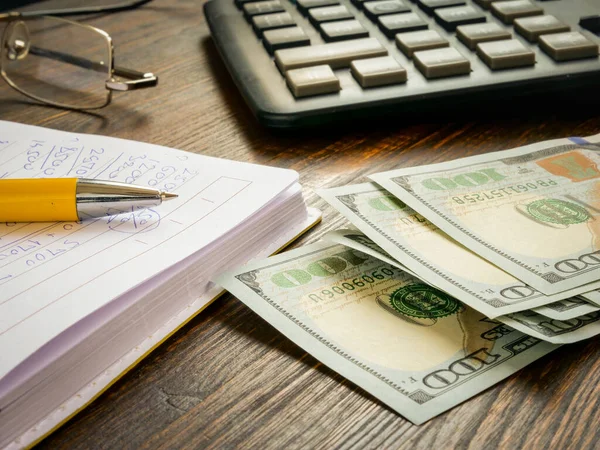 Dollars and a calculator with home finance calculations. — Stock Photo, Image