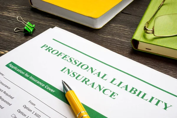 Yrkesansvarsförsäkring och gul penna för undertecknande. — Stockfoto