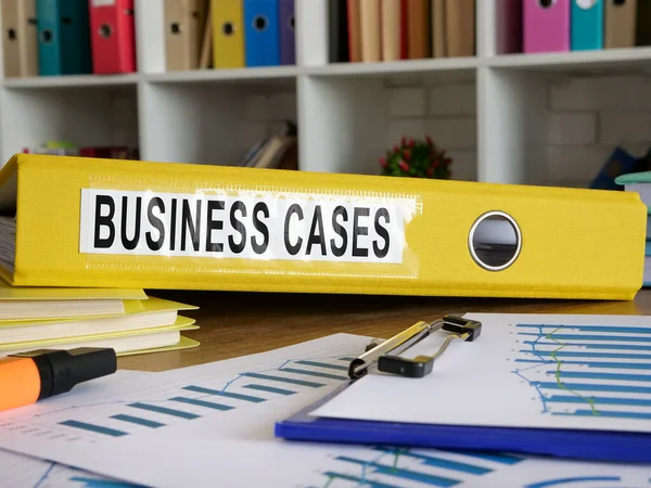 Business cases in the yellow folder on the desk.