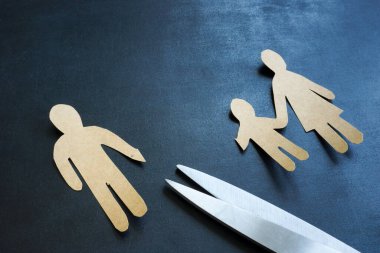 Boşanma kavramı. Makasla kesilmiş heykelciği olan kağıttan yapılmış bir aile..