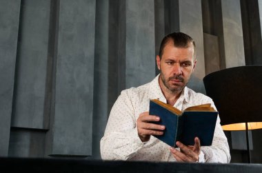 Modern odada kitap okuyan bir adamın portresi. Bilgi ve deneyim..