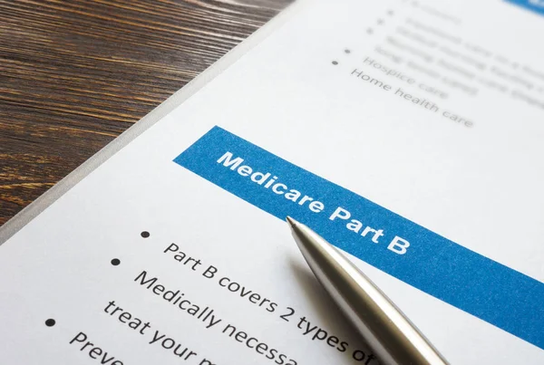 Medicare part B cover list and metal pen. — Stock Photo, Image