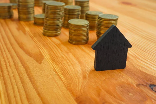 Малый дом и стопки монет как символ ипотеки и кредитов. — стоковое фото