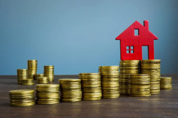 Pile de pièces de monnaie et de maison. Hausse du coût immobilier. — Photo