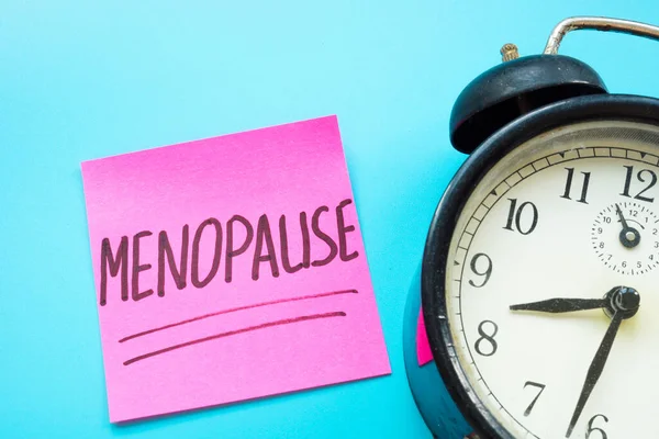 Menopausa palavra manuscrita no adesivo e despertador. — Fotografia de Stock