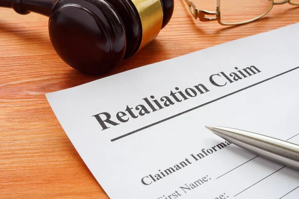 Retaliation claim lying on the desk with gavel. — Stock Photo, Image