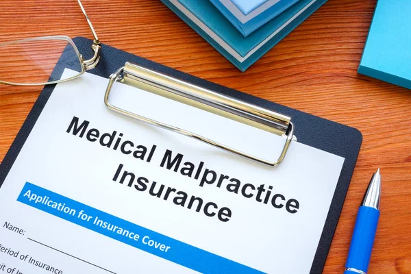 Medical malpractice insurance application and clipboard. — Stock Photo, Image
