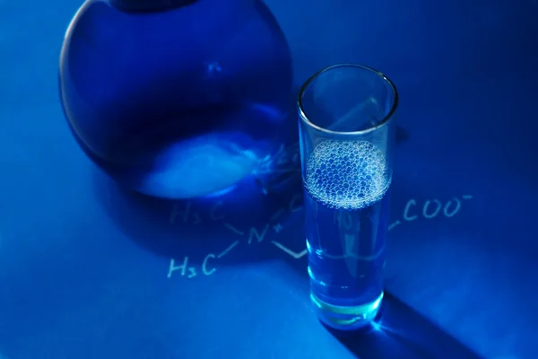 Verrerie de laboratoire sur fond bleu. Chimie - concept photo — Photo