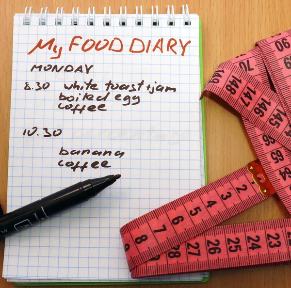 Measuring tape, a marker and a notepad with a food diary — Stock Photo, Image