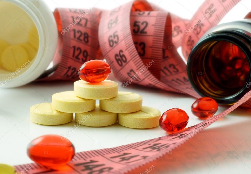 Measuring tape and bottle with pills. supplements of diet