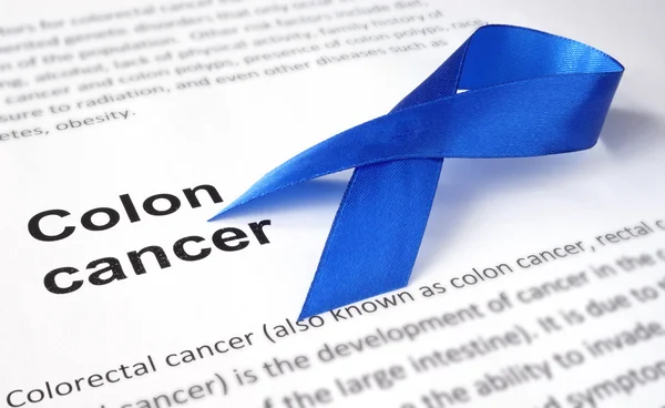 Paper with colon cancer and dark blue ribbon. — Stock Photo, Image