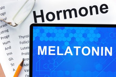 Kağıtları hormonlar listesi ve tablet ile kelime melatonin.