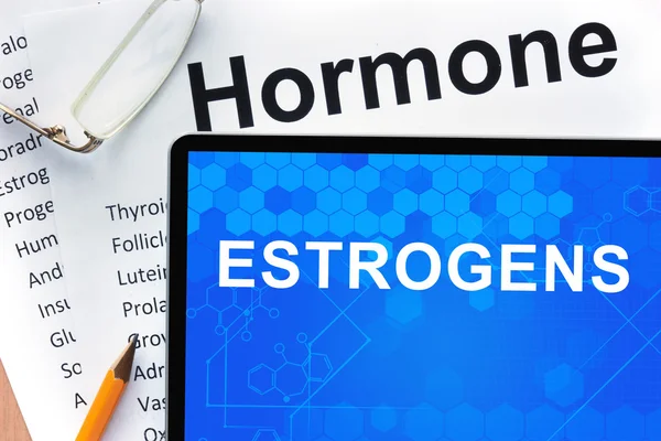 Papper med hormoner lista och tablett med ord östrogener . — Stockfoto