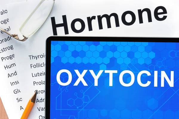 Papeles con lista de hormonas y tabletas con palabras oxitocina . —  Fotos de Stock