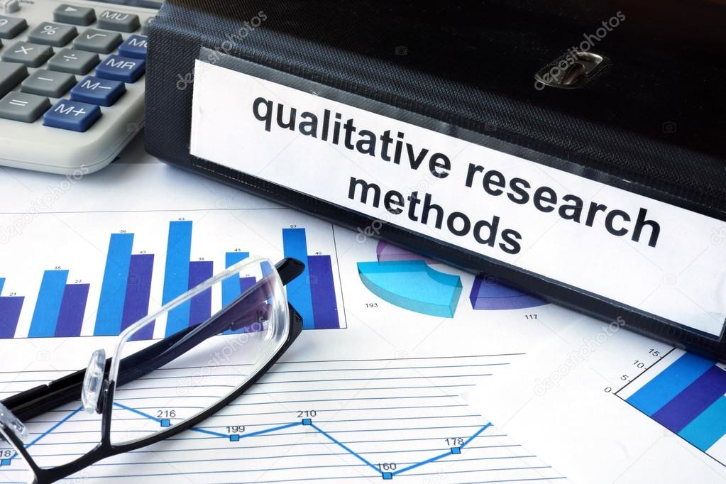 File folder with words words qualitative research methods and financial graphs.