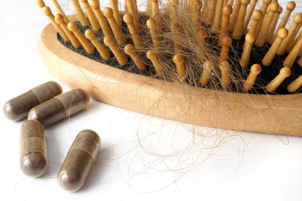 Pills for hair loss treatment and  brush with lost hair on it. — Stock Photo, Image