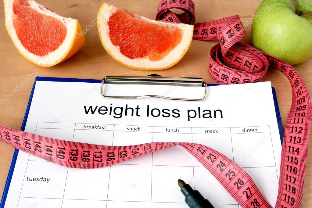 Paper with weight loss plan and grapefruit