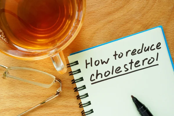 Бумага с Как снизить уровень холестерина на деревянной доске . — стоковое фото