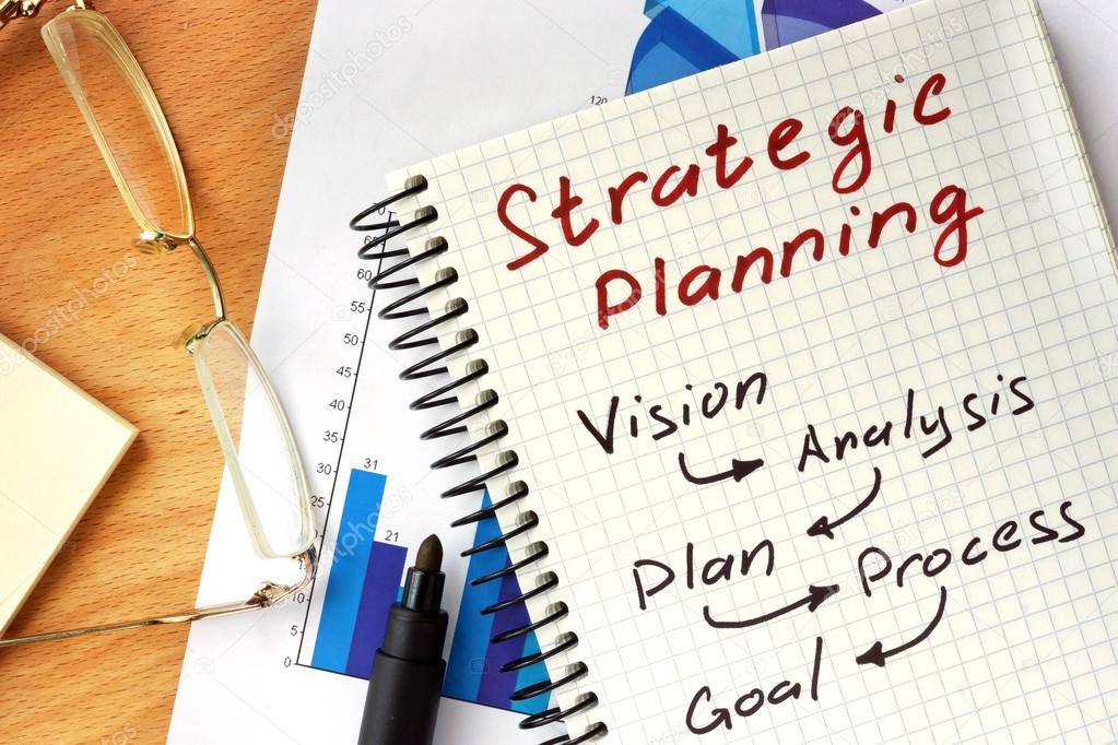 Notepad with  Strategic planning concept on a wooden board.