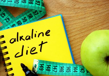 Notepad with alkaline diet, apple and measure tape clipart