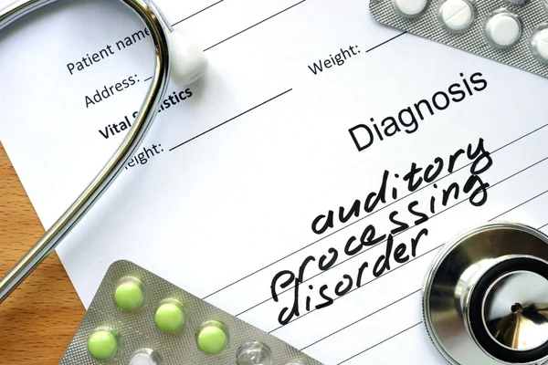 Diagnostische formulier met diagnose auditieve verwerking wanorde en pillen. — Stockfoto