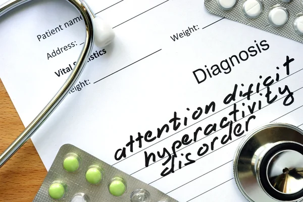 Diagnoseform mit Diagnose Aufmerksamkeitsdefizit-Hyperaktivitätsstörung und Pillen. — Stockfoto